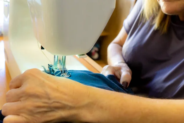 針と服をミシンで縫うという類のない女性の手 — ストック写真