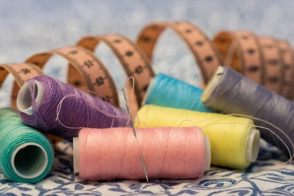 Bir mezura ile çeşitli renk iplikleri kümesi