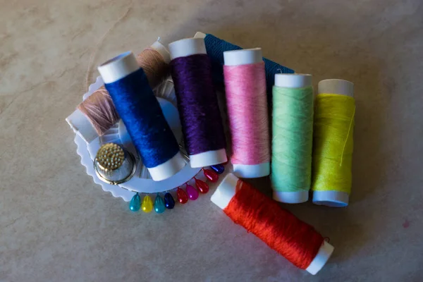 Çeşitli renkte iğne ve yüksük desenli iplik makaraları