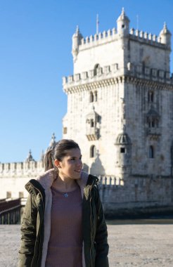 Lizbon, Portekiz 'deki Belem Kulesi' nin önündeki kız güneşli bir günde yan tarafa bakıyor..