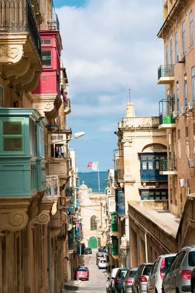 Açık bir günde balkonları ve mavi pencereleri olan tipik Malta caddesi.