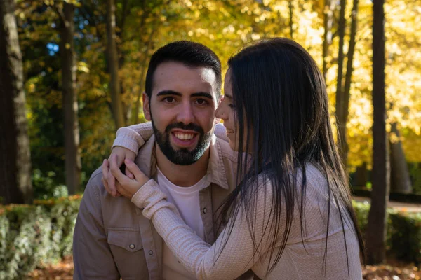 Sonbaharda yapraklar ve ağaçlarla çevrili bir çift.