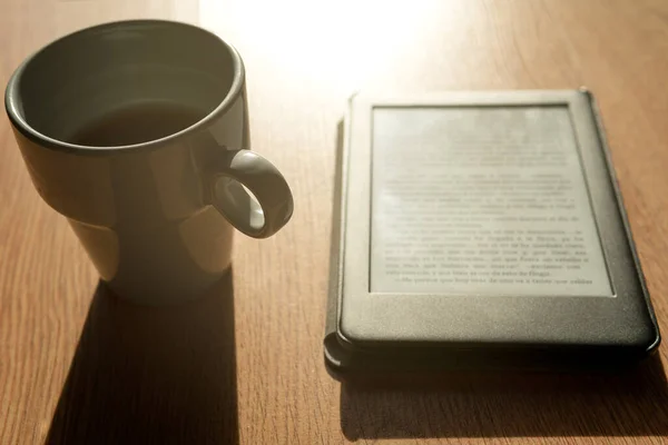 E-kitap ve kahve bardağı yakın planda..