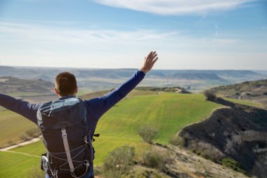 Dağın zirvesinde zaferini kutlayan tanınmamış genç adam. Başarı ve azim kavramı.