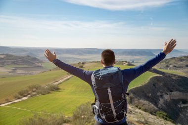 Dağın zirvesinde zaferini kutlayan tanınmamış genç adam. Başarı ve azim kavramı.