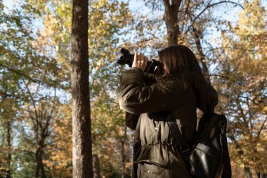 Genç kız sonbaharda bir ormanda fotoğraflandı.