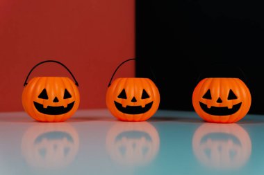 Kırmızı ve siyah arkaplanda üç Cadılar Bayramı balkabağı