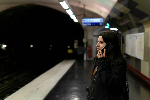 Young tourist talking on his smartphone in the Paris subway
