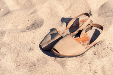 Sandals on the sand on the beach with plenty of copy space