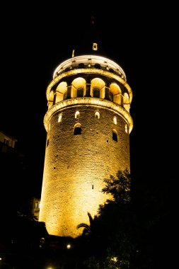Galata Kulesi gün batımında siyah arkaplan ve portre biçiminde ön planda.