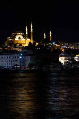 Gün batımında Süleyman Camii 'nin manzarası ışıklar açıkken ve Boğaz ışıkları yansıtırken..
