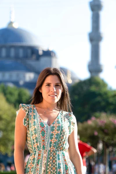 Young woman in the foreground with the blue mosque in the background
