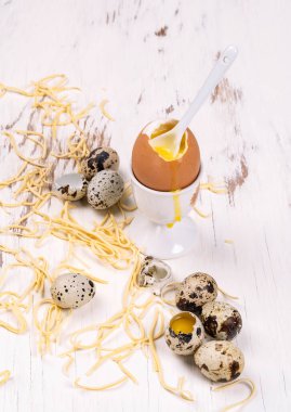 Beyaz ahşap arka planda kuru erişteli bıldırcın yumurtası.