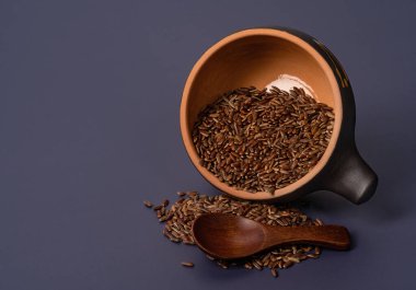 Mavi arka planda seramik bir kasede kahverengi pirinç.