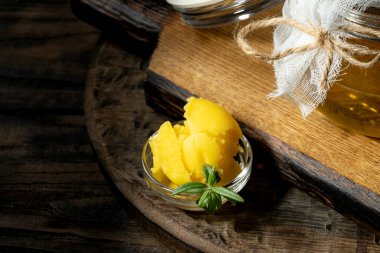 Saf ya da eritilmiş kahve. Sağlıklı yağlarla beslenme konsepti. Cam kavanozlar. Koyu tahta bir masada..