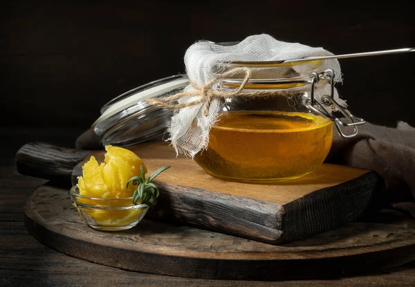 Saf ya da eritilmiş kahve. Sağlıklı yağlarla beslenme konsepti. Cam kavanozlar. Koyu tahta bir masada..