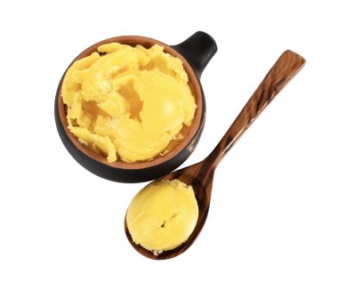 Beyaz arka planda kaşıkla kasede erimiş tereyağı..