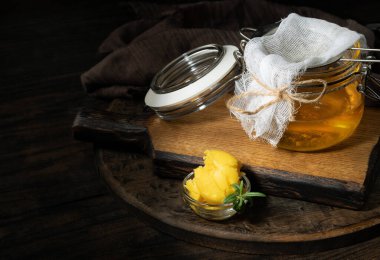 Saf ya da eritilmiş kahve. Sağlıklı yağlarla beslenme konsepti. Cam kavanozlar. Koyu tahta bir masada..