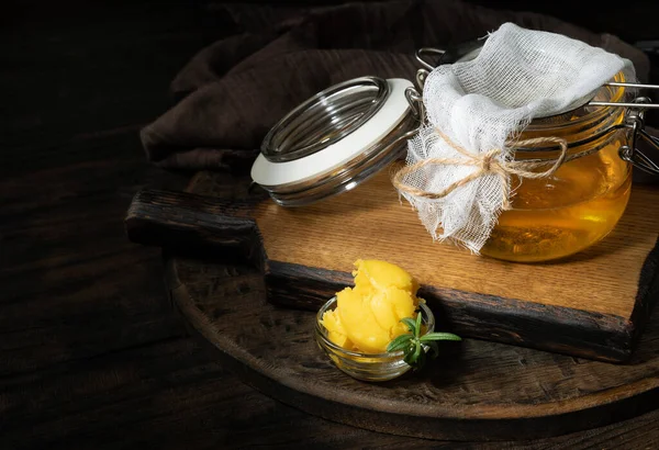 Saf ya da eritilmiş kahve. Sağlıklı yağlarla beslenme konsepti. Cam kavanozlar. Koyu tahta bir masada..