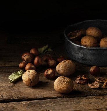 Koyu tahtada ceviz, ahşap kasede ceviz çekirdeği, geniş pankart ya da panorama..