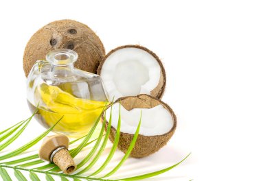 Hindistancevizi ve ahşap bir masada yeşil palmiye yaprağı bulunan bir şişede hindistan cevizi yağı sağlıklı yiyecekler, cilt bakımı konsepti. Vejetaryen yemeği