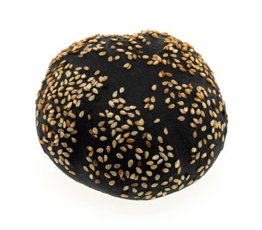 Beyaz arka planda susam tohumlarıyla kaplanmış siyah yuvarlak ekmek.