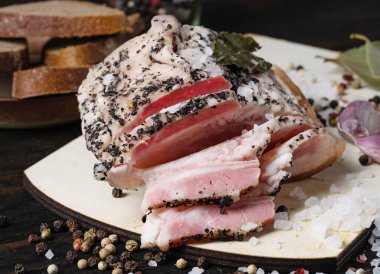 Biberli tuzlanmış domuz yağı, sarımsak, ahşap bir masada soğan.