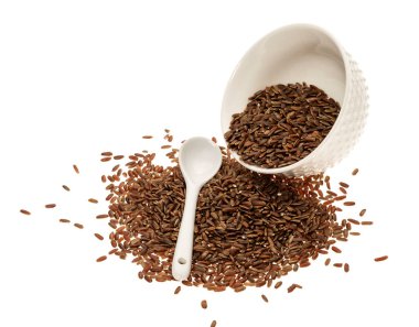 Beyaz arka planda beyaz kaşıkla seramik bir kasede kahverengi pirinç.