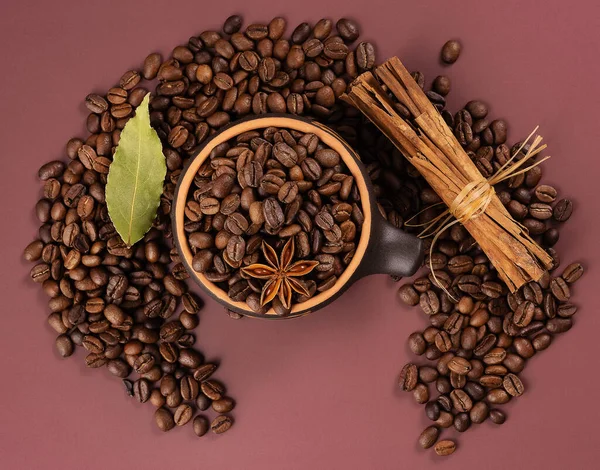 シナモン入りのコーヒー豆とダークピンクの背景の星のアニスのカップ ストック画像