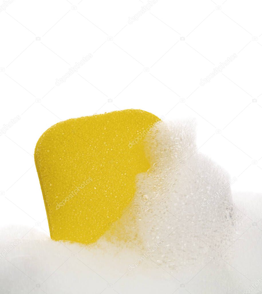 Yellow sponge in soapy foam on a white background. Cleaning concept.