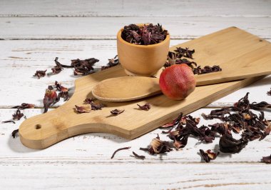 Hibiscus çayı, beton arka planda kaşıkla mutfak tahtasında.