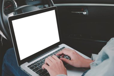 Asyalı bir kadın arabada oturmuş klavyede yazı yazıyor ve dizüstü bilgisayar kullanıyor. Krom tuşlu yeşil ekran görüntüsü, delta covid salgını sırasında sosyal mesafeler, serbest çalışma, yeni normal kavram.