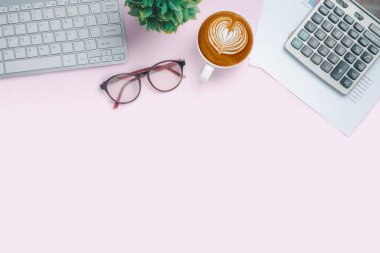 Üzerinde analiz çizelgesi, grafik, gözlük, kahve ve hesap makinesi olan pembe masa. Kopyalama alanı olan üst görünüm. Çalışma masası konsepti.