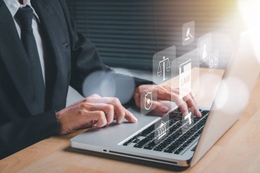 Ofis masasında holografik hukuk simgesi olan dizüstü bilgisayar kullanan erkek avukat, terör, suç, yargı, karar, adalet ve hukuk kavramı