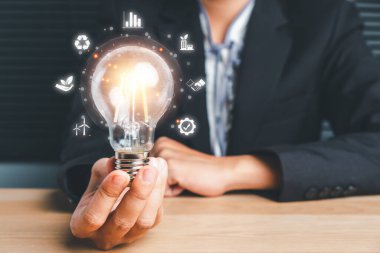 Sanal ekranda ESG ikonlu bir ampulü tutan iş kadını, ESG Çevre, Sosyal ve Kurumsal Yönetim kavramı