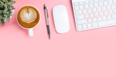 Klavye bilgisayarlı ofis masası, kalem, fare, pembe arka planda bir fincan kahve, fotokopi alanı olan üst görünüm,.