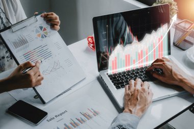 Gelir tablosu ve grafiklerini analiz eden iş ekibi, holografik grafikler ve borsa istatistikleri ile bilgisayar üzerinde çalışan iş ekibi kar, iş büyümesi, ilerleme veya başarı kavramı elde etti.
