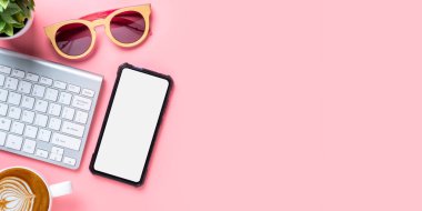 Bilgisayarlı ofis masası, boş ekran akıllı telefon, pembe arka planda bir fincan kahve, fotokopi alanı olan üst görünüm,.