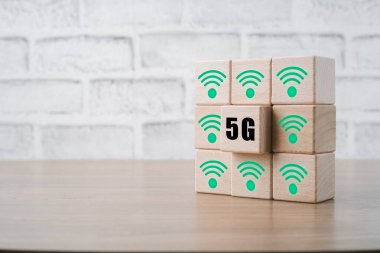 Küresel iletişim ağı kavramı, ahşap masa üzerinde 5G ve wifi ikonu olan tahta küpler, dünya çapında iş, yüksek hızlı mobil internet, yeni nesil ağlar. Karışık ortam.