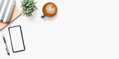 Boş ekran akıllı telefonu olan ofis masası, kalem, defter, beyaz arka planda bir fincan kahve, fotokopi alanı olan üst görünüm,.