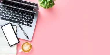 Bilgisayarlı ofis masası, boş ekran akıllı telefon, bir fincan kahve, pembe arka planda kalem, fotokopi alanı olan üst görünüm,.