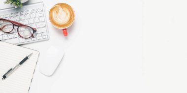 Klavye bilgisayarlı ofis masası, kalem, gözlük, not defteri, kahve fincanı, beyaz arka planda fare, fotokopi alanı olan üst görünüm,.