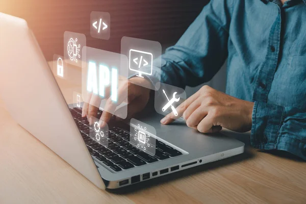 API - Application Programming Interface, Woman using laptop computer with VR screen API icon on office desk, Software development tool, modern technology, internet and networking concept.	