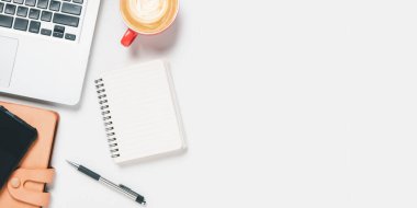 Bilgisayarlı ofis masası, kalem, akıllı telefon, defter, beyaz arka planda bir fincan kahve, fotokopi alanı olan üst görünüm,.