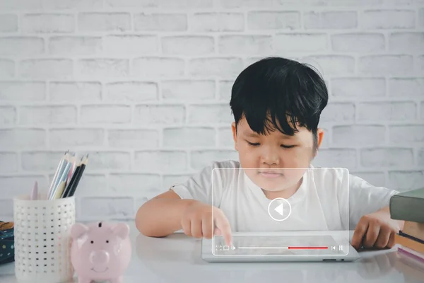 Video streaming on internet, Asian little boy watching online movie or TV series on digital tablet, Concept about subscription based live digital stream.