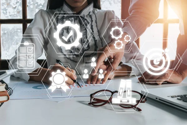 Quality management with QA (assurance), QC (control) and improvement, Business team discussing data with document data with VR screen quality management icon on desk table.