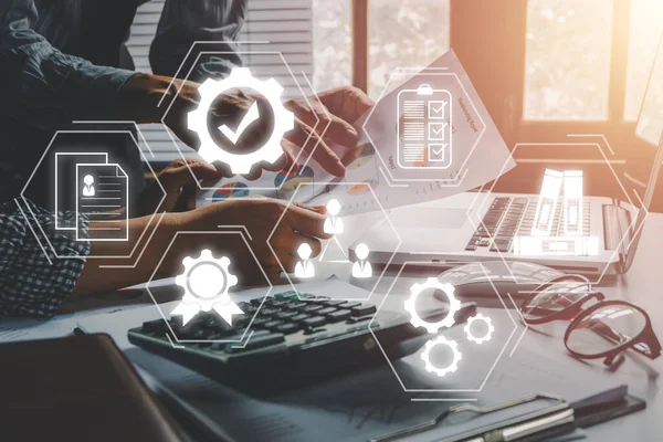 Quality management with QA (assurance), QC (control) and improvement, Business team discussing data with document data with VR screen quality management icon on desk table.