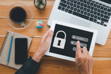 Ekran ekranında giriş ve parola, siber güvenlik konsepti, veri koruması ve güvenli internet erişimi olan dijital tablet kullanan kişi.