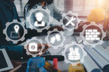 İnşaat ekibi çalışanı VR ekran ikonu, bina planı ve bina modeli ile birlikte mühendislik araçlarıyla çalışıyor. İnşaat konsepti.