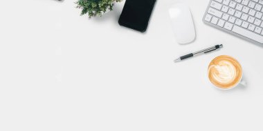 Üst Manzara, bilgisayar klavyesi, fare, akıllı telefon, kalem ve kahve fincanı, kopyalama alanı olan Beyaz Ofis masası...